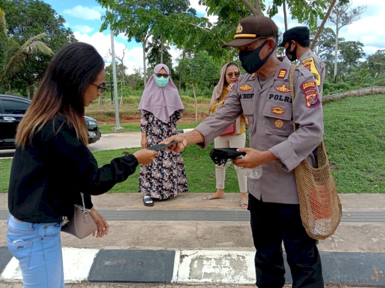 Kapolsek Sota saat membagikan masker untuk pengunjung boven PLBN Sota