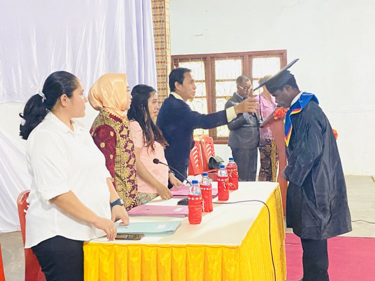 proses wisuda, digesernya tali toga oleh kepala sekolah SMK Yaleka Maro Merauke, Martinus Rudy Adam,S.Pd