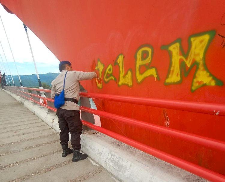 Polisi Membersihkan Bekas Coretan Disepanjang Jembatan Youtefa/ist