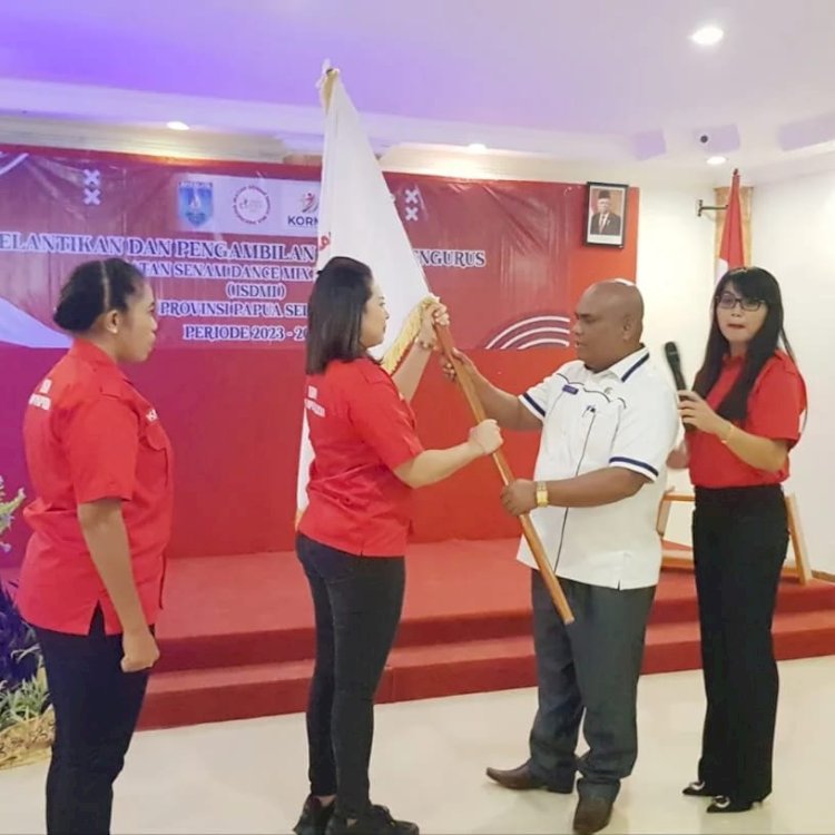 Ketua Umum ISDMI Papua Selatan, Agustina Sri Tunay saat menerima Pataka dari ketua harian KORMI Provinsi Papua Selatan, Sulaiman Jambormias