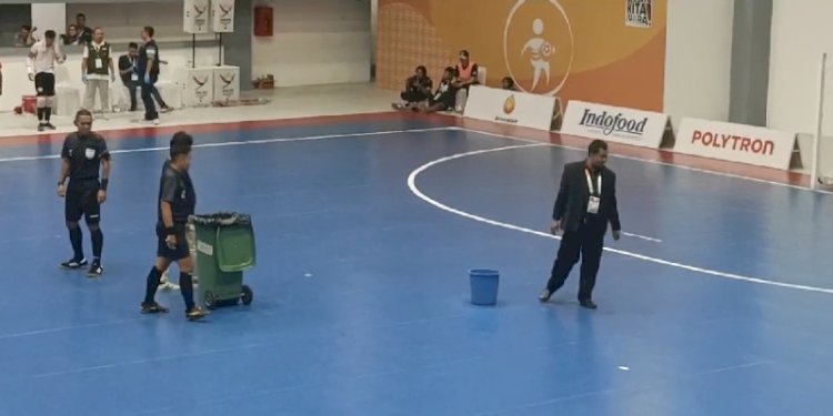 Petugas menampung bocoran air hujan di Lapangan Futsal PON XXI/Repro