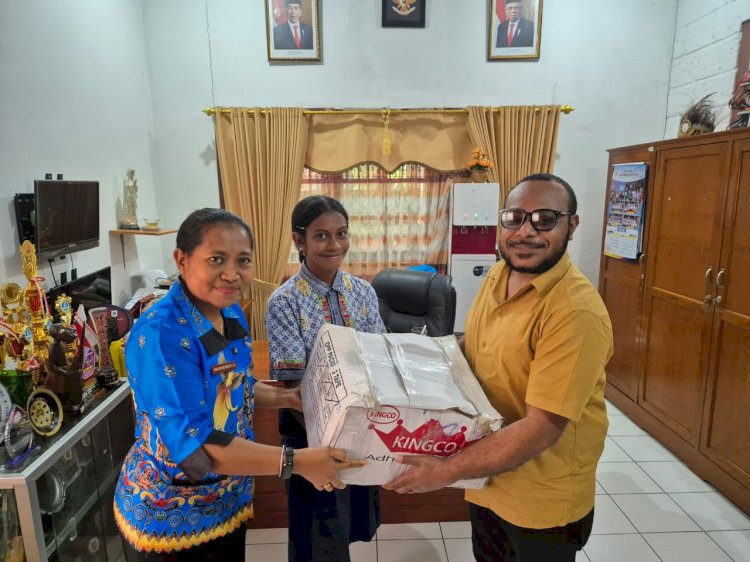Ketua Alumni Otniel Deda menyerahkan bantuan buku dan alat tulis kepada perwakilan siswa dan kepala sekolah SMP YPPK Santo Paulus Abepura, Maria Noviyanti Widiastuti.