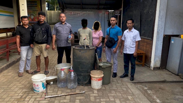 Petugas Sat Resnarkoba Polres Merauke mengamankan dua terduga pembuat minuman keras jenis sopi beserta peralatan produksi saat penggerebekan di Jalan KPG, Selasa (12/8/2025). Dari lokasi, polisi menyita tong penyulingan, galon air mineral, ember, dan sopi siap edar.